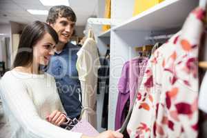 Couple selecting a dress while shopping for clothes