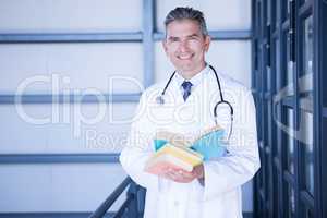 Portrait of male doctor standing with medical book
