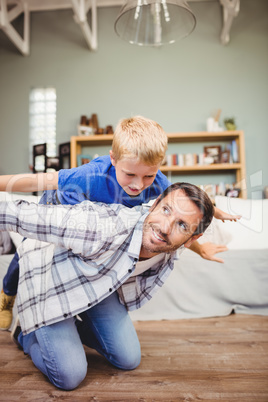 Happy father playing with son on hardwood floor