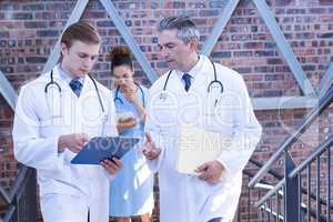 Doctors discussing medical report on staircase
