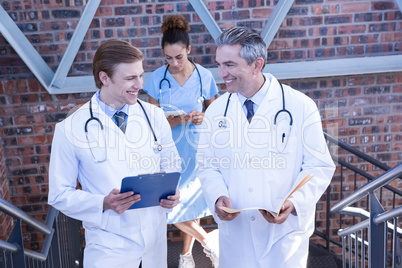 Doctors discussing medical report on staircase