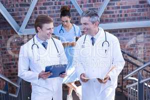 Doctors discussing medical report on staircase