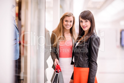 Portrait of two beautiful women window shopping