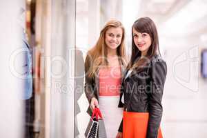Portrait of two beautiful women window shopping