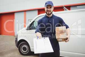 Delivery man holding clipboard and package