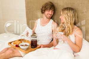 Cute couple having breakfast in bed