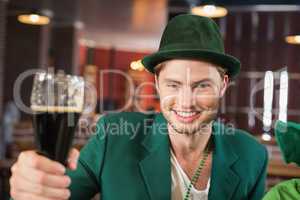 Man with a hat toasting a beer