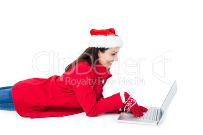 Brunette with santa hat lying on the floor using her laptop