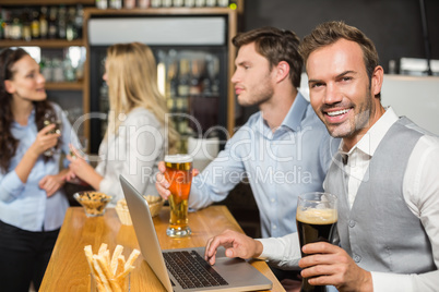 Men working on laptop while women talk behind