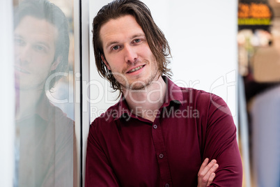 Portrait of man leaning outside the shop