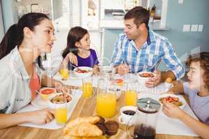 Happy family talking while having breakfast