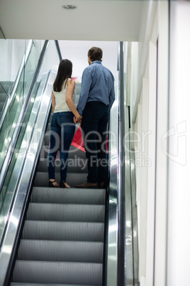 Couple standing on escalator