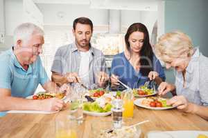 Family sitting at dining table with food