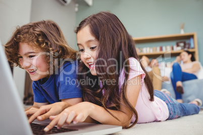 Close-up of siblings using laptop at home