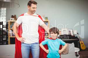 Smiling father and son in superhero costume