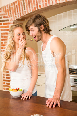 Cute couple eating a bowl of fruit salad