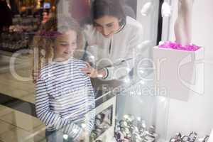 Mother and daughter selecting a wrist watch from shop display