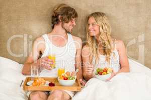 Cute couple having breakfast in bed