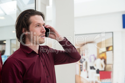 Man talking on mobile phone outside a shop