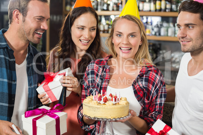 Woman looking at camera with cake in hands