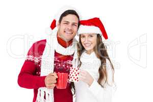 Happy couple with santa hats holding mug