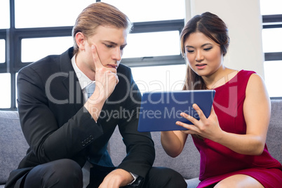 Businessman and businesswoman using digital tablet