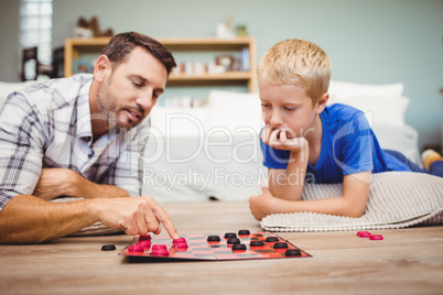 Close-up of father and son playing checker game