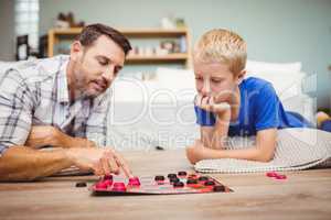 Close-up of father and son playing checker game