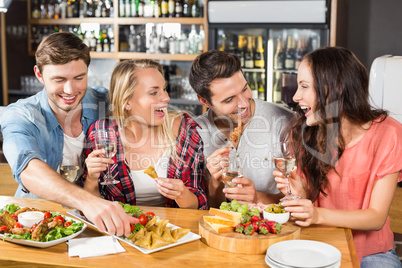 Friends drinking white wine and eating