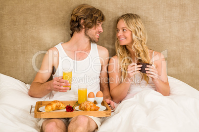 Cute couple having breakfast in bed