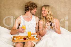 Cute couple having breakfast in bed