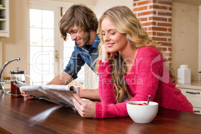 Cute couple reading the newspaper