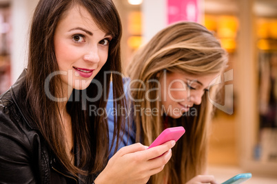 Two beautiful women using their phone