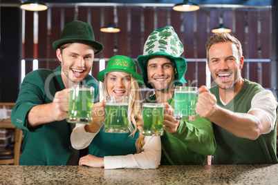 Friends wearing St. Patricks day associated clothes toasting