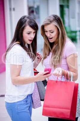 Two beautiful women looking at phone