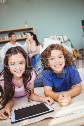 Close-up portrait of happy siblings with digital tablet