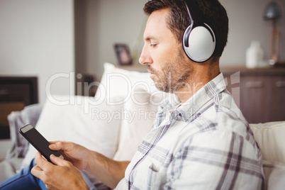 Man using mobile phone while wearing headphones