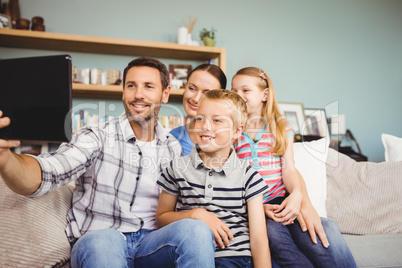 Happy family taking selfie from digital tablet