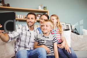 Happy family taking selfie from digital tablet