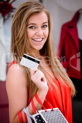 Portrait of happy woman showing her credit card while shopping