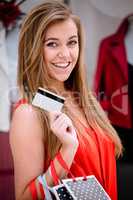 Portrait of happy woman showing her credit card while shopping