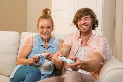 Cute couple playing video games sitting on the couch