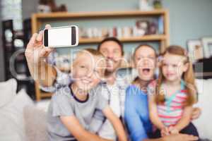Man taking selfie of family with mobile phone