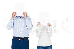 Couple covering face with paper