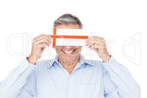 Handsome man covering eyes with gift