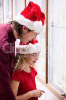Father and daughter in Christmas attire looking at jewelry displ