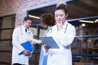 Female doctor looking at digital tablet near library