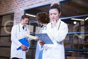 Female doctor looking at digital tablet near library