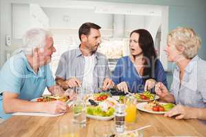 Family discussing while sitting at dining table