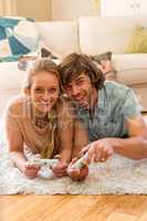 Cute couple lying on the carpet playing video games